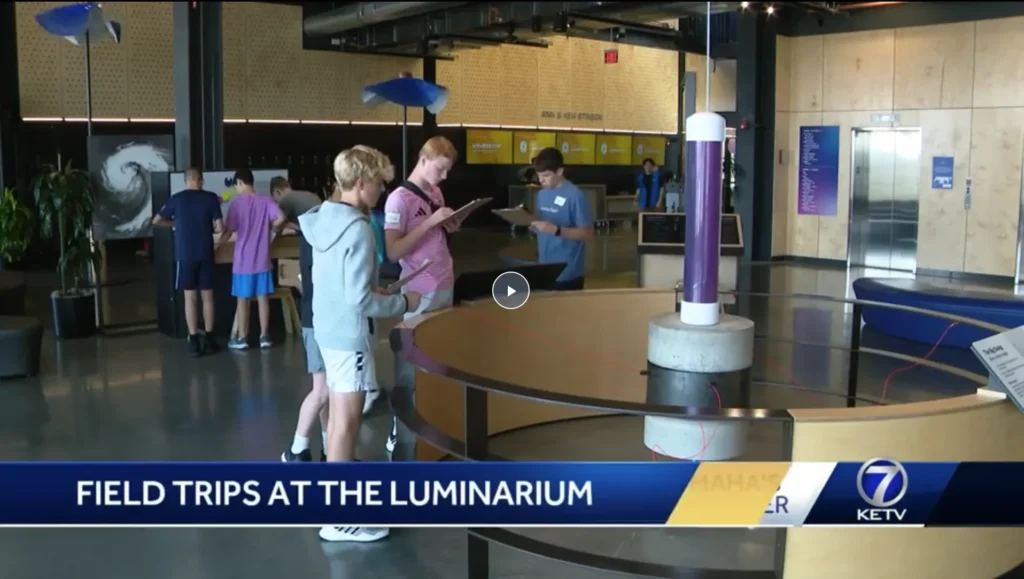 Students on a field trip walking through the Luminarium with clipboards. Text overlay reads Field Trips at the Luminarium.